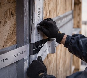 Instalador sellando con cinta AERUM la unión entre membrana y OSB
